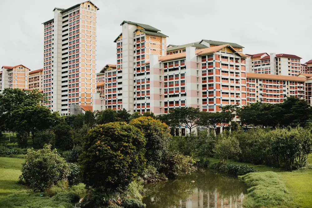 Conjunto de edifícios residenciais diante de uma área verde.